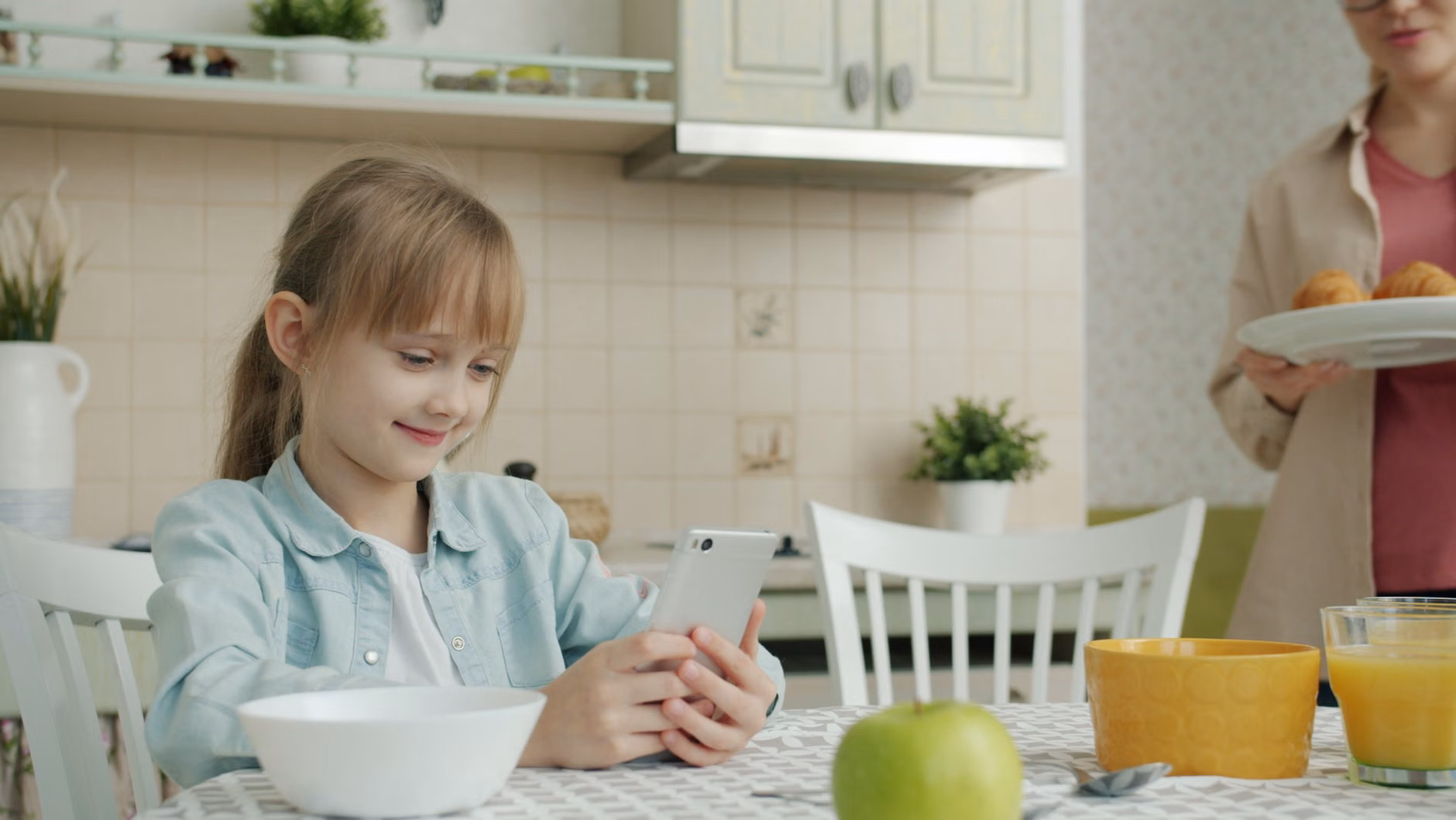 Parent managing digital security at a kitchen table.