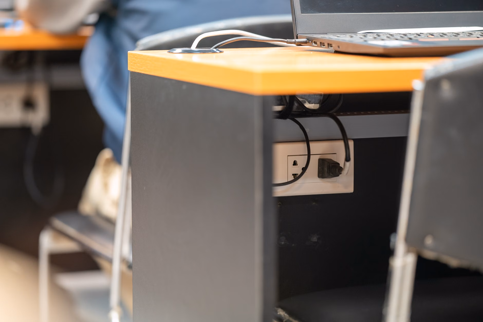 Detailed view of cable management under a modular desk.
