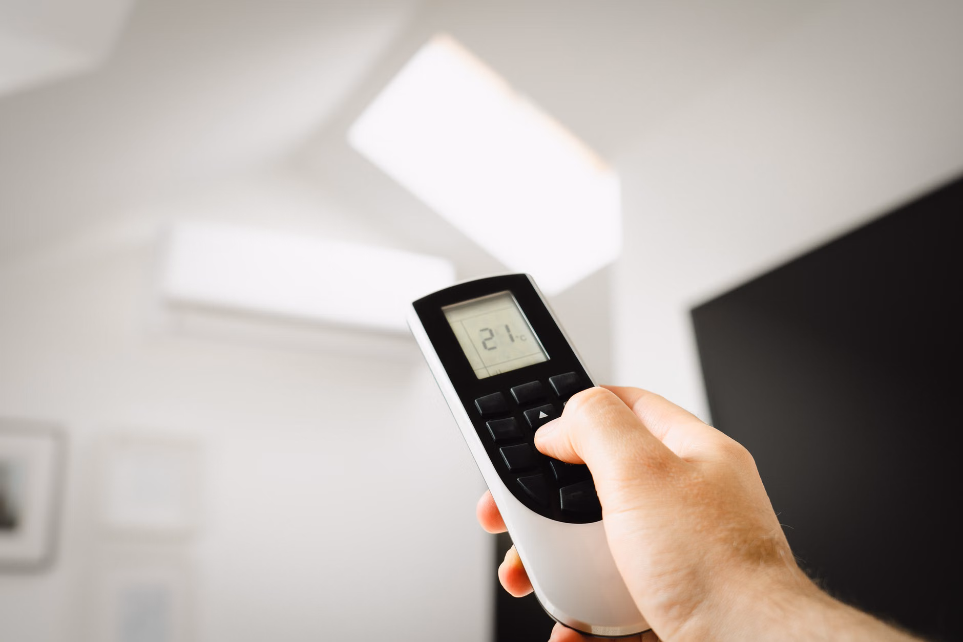 Person adjusting a smart home thermostat on a smartphone