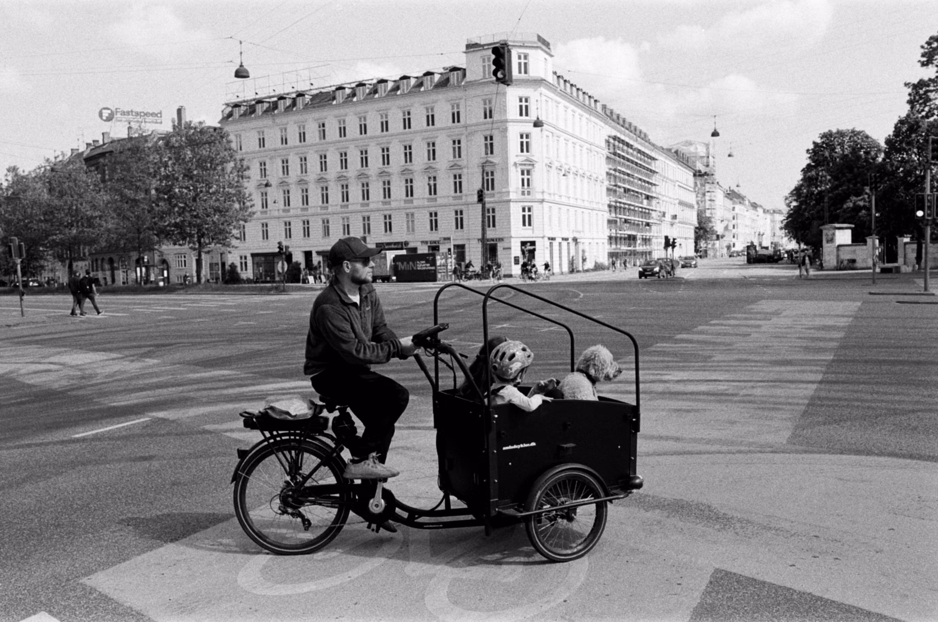 Child wearing a safety helmet in a cargo bike box.