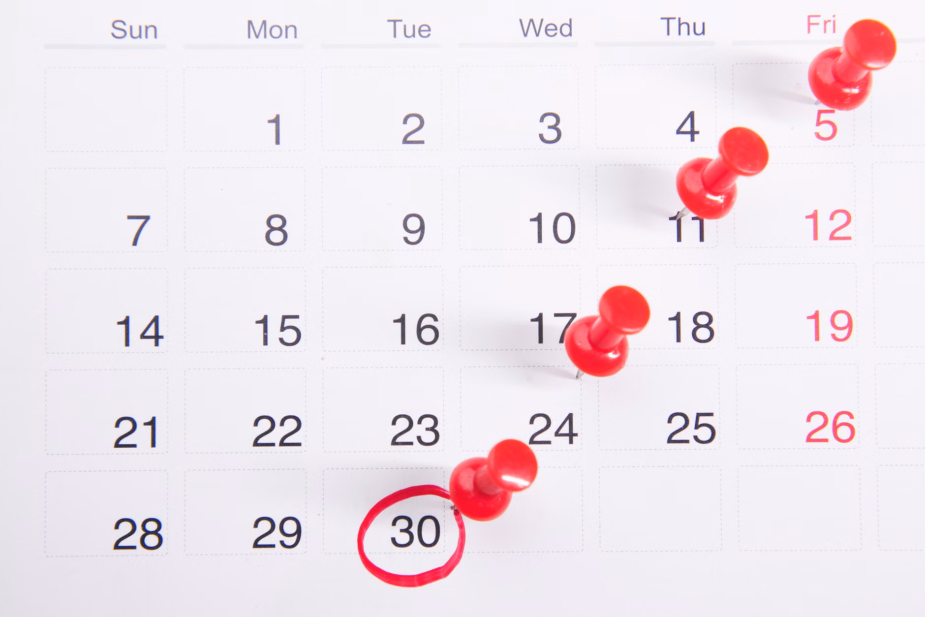 A close-up of a travel planning calendar with marked dates for off-peak travel.