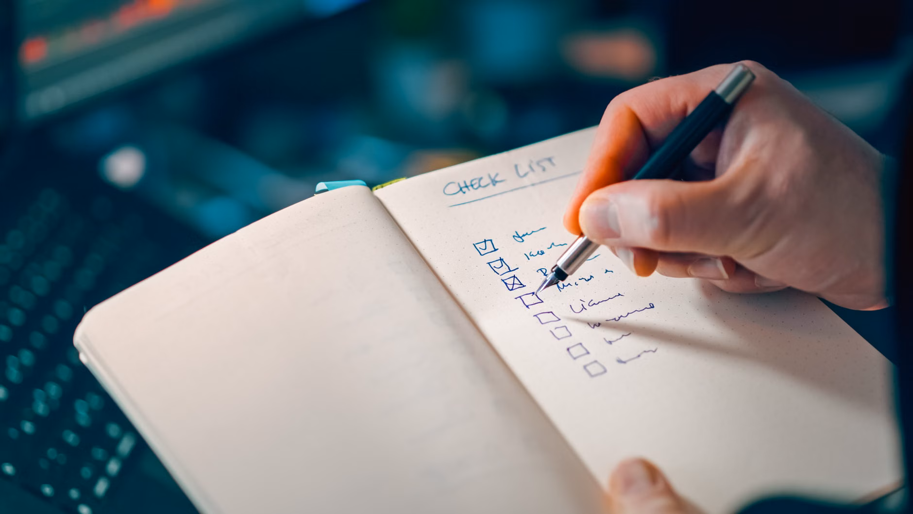 Hand checking off recurring expenses on a paper list.