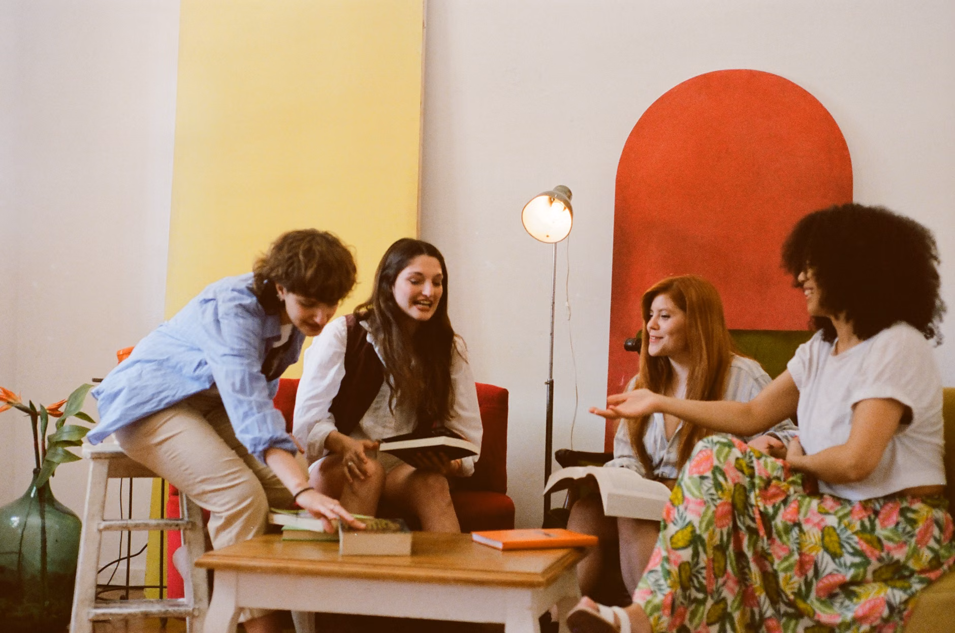 A group of friends discussing books in a comfortable, bright living room.