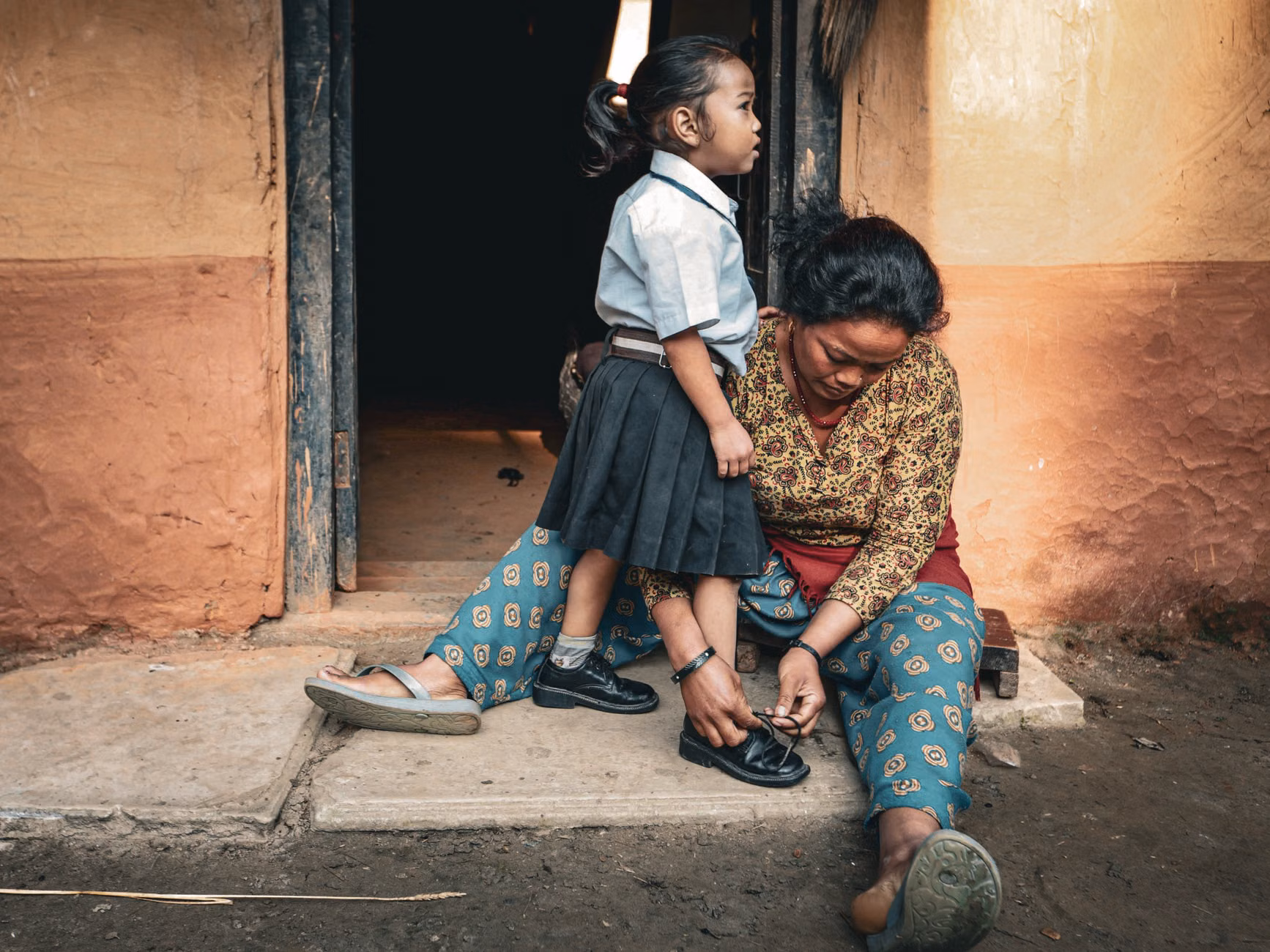A parent and child preparing school bags and clothes for the week ahead.