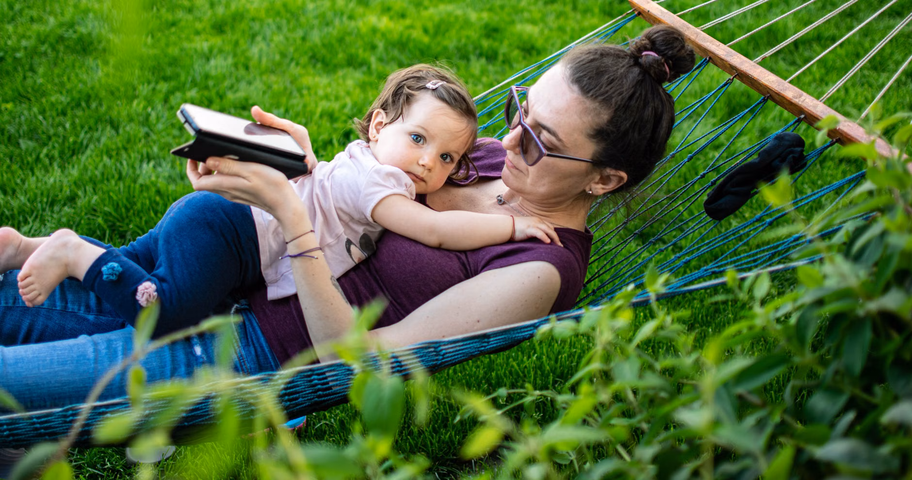 Parent and child resting in a small, lush community garden in the city.