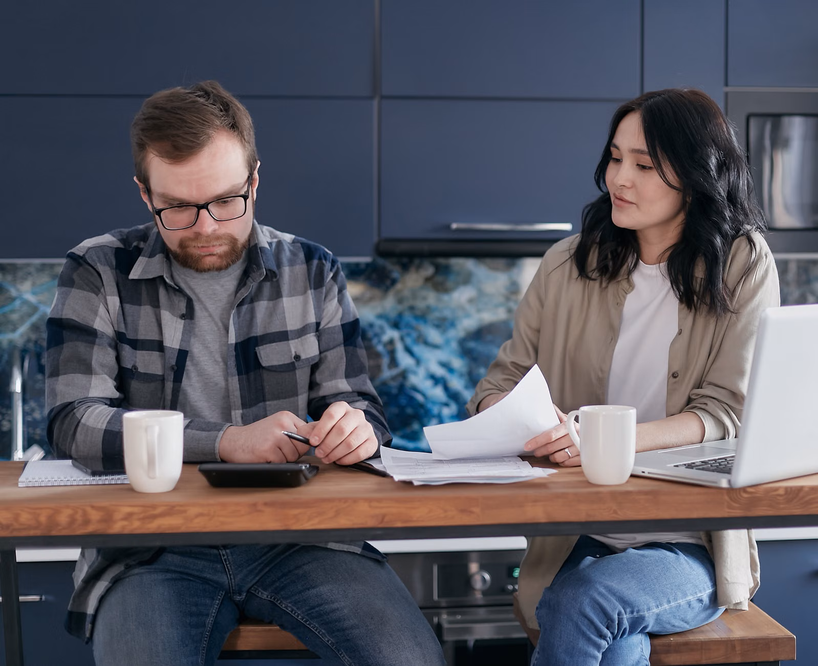 A couple discussing family finances on a tablet in a relaxed setting.