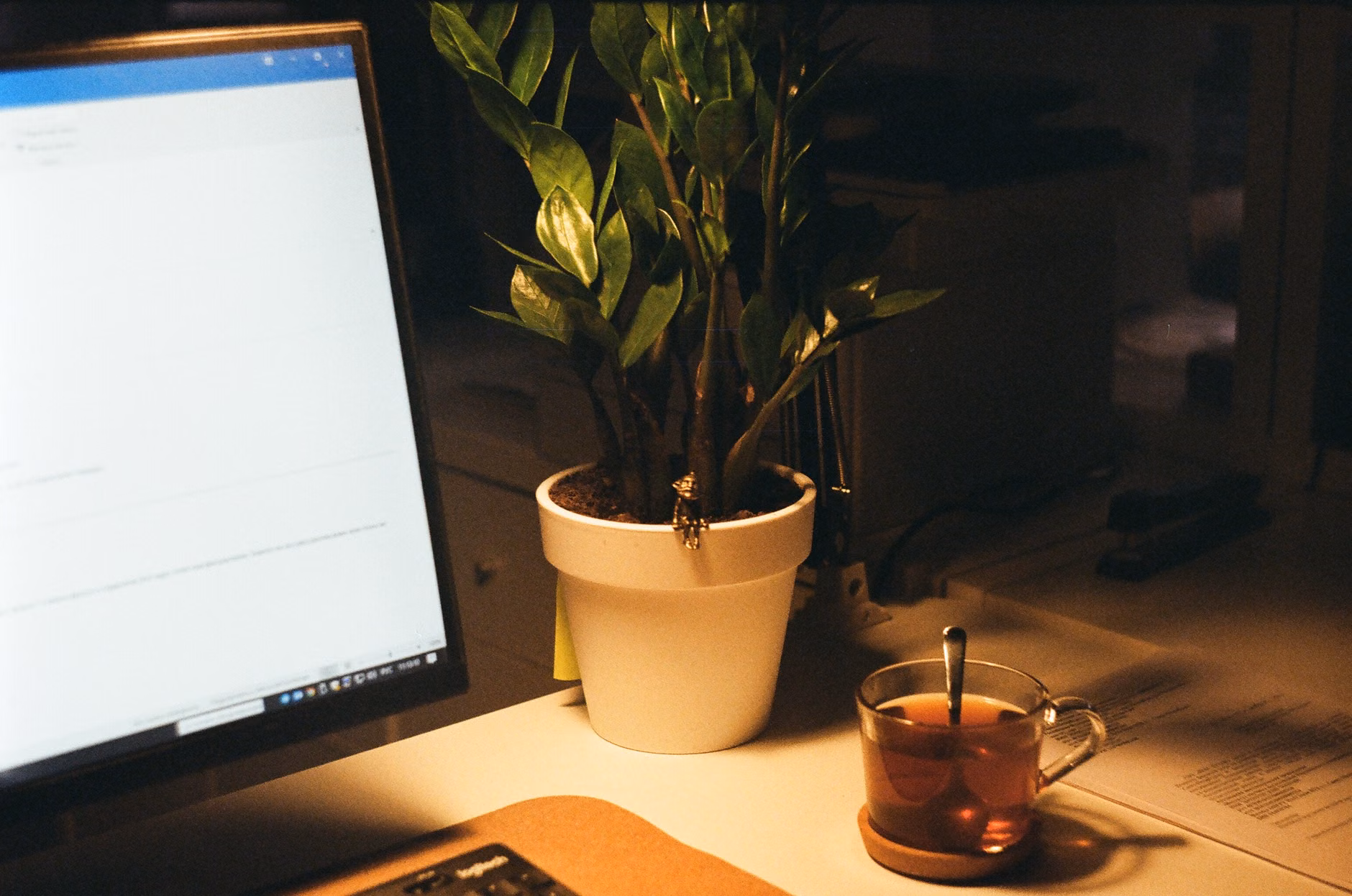A minimalist desk setup with a cup of tea and a turned-off device.