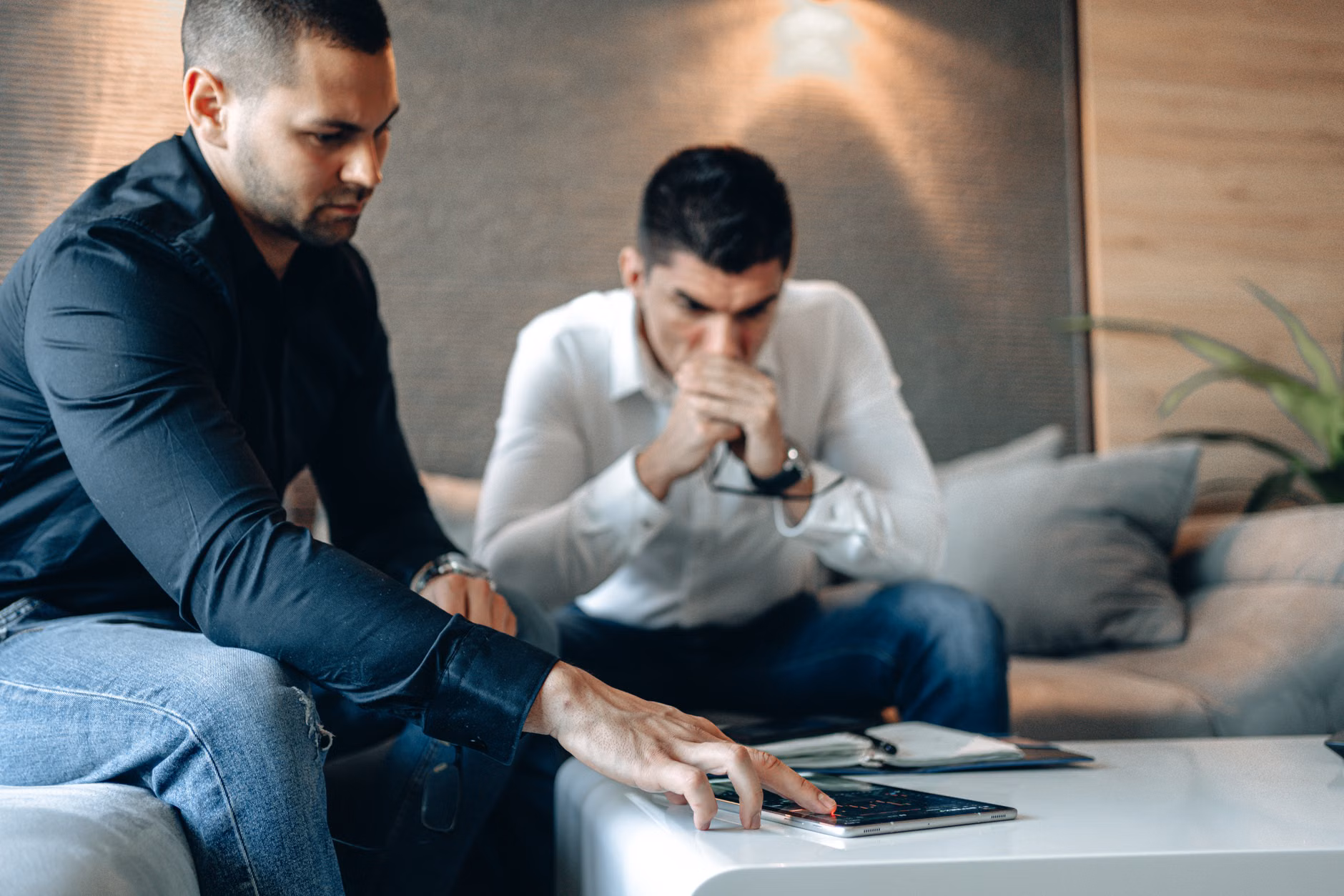 A young couple reviewing energy savings on a tablet in their kitchen.