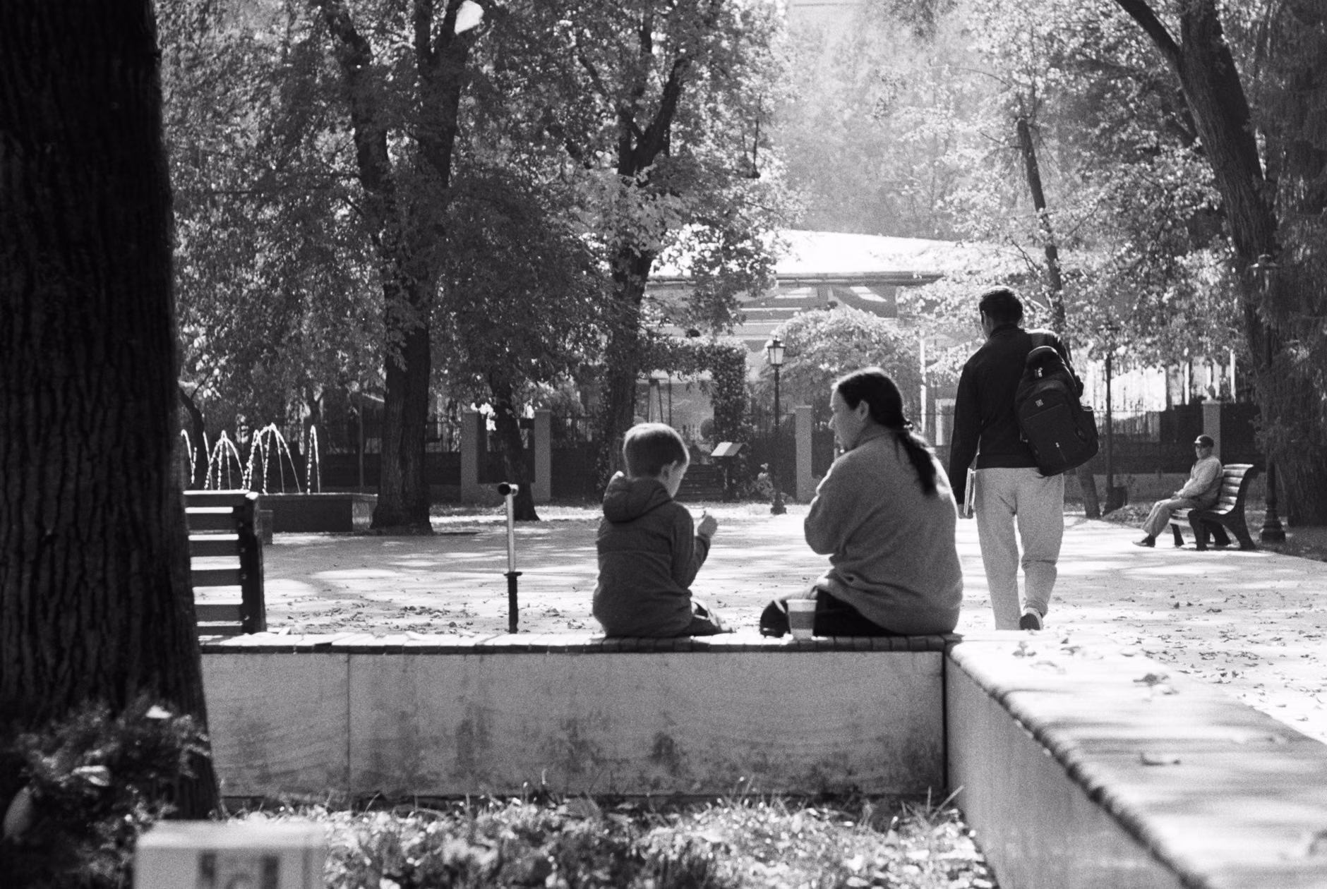 Family sitting on a bench in a quiet urban square.