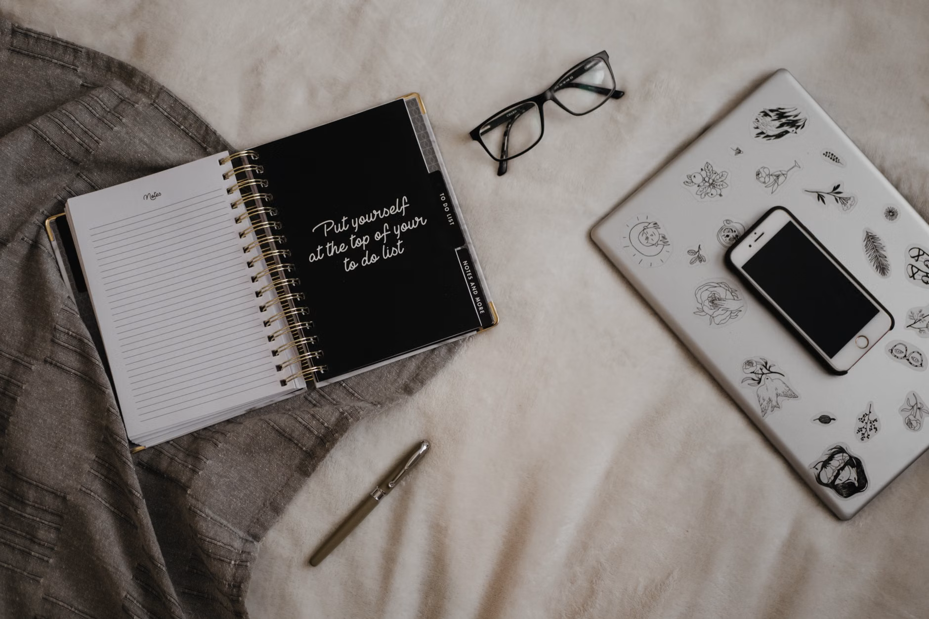 A desk setup for planning a reading list and personal growth goals.