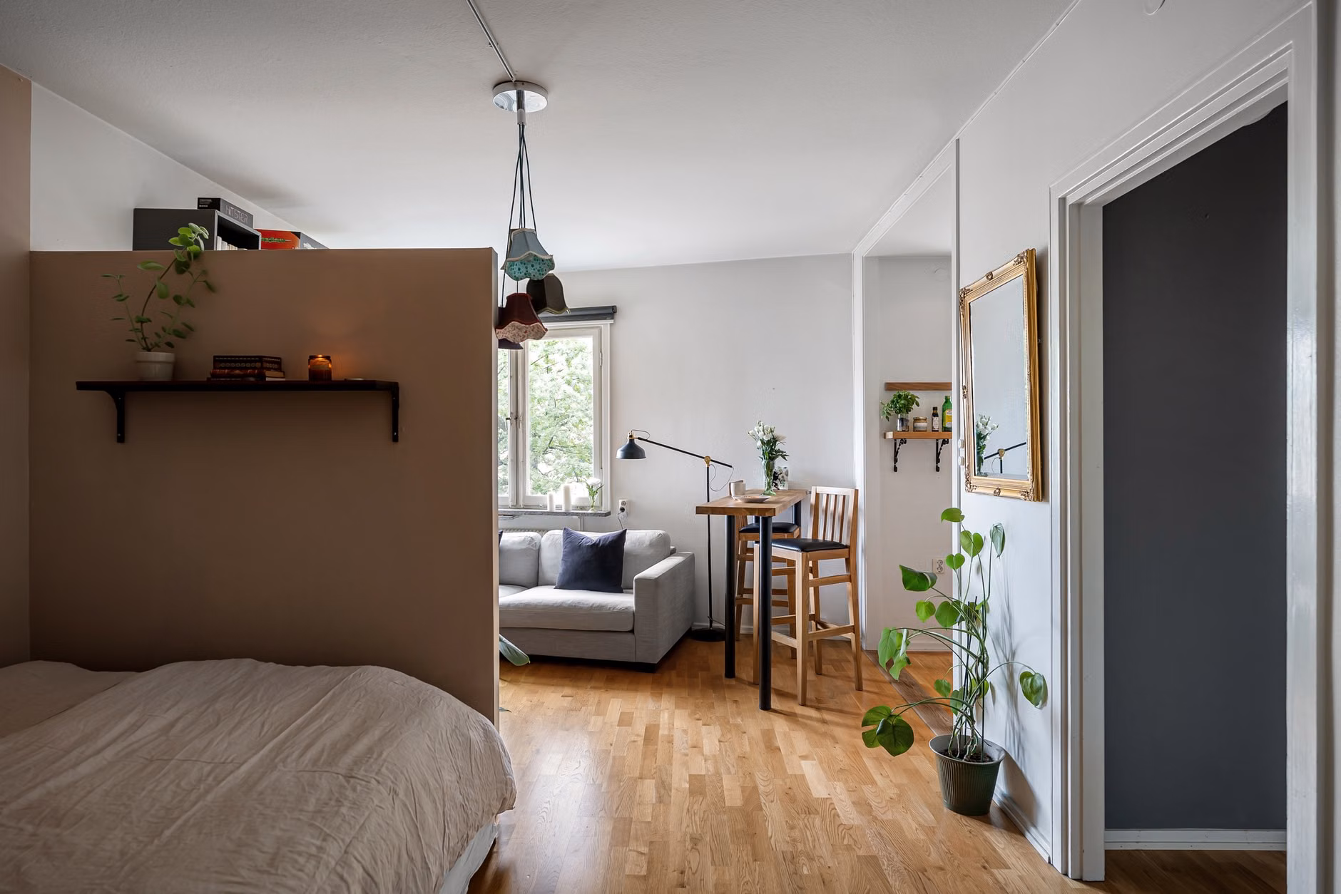 A room divider shelf separating a workspace from a home living area.