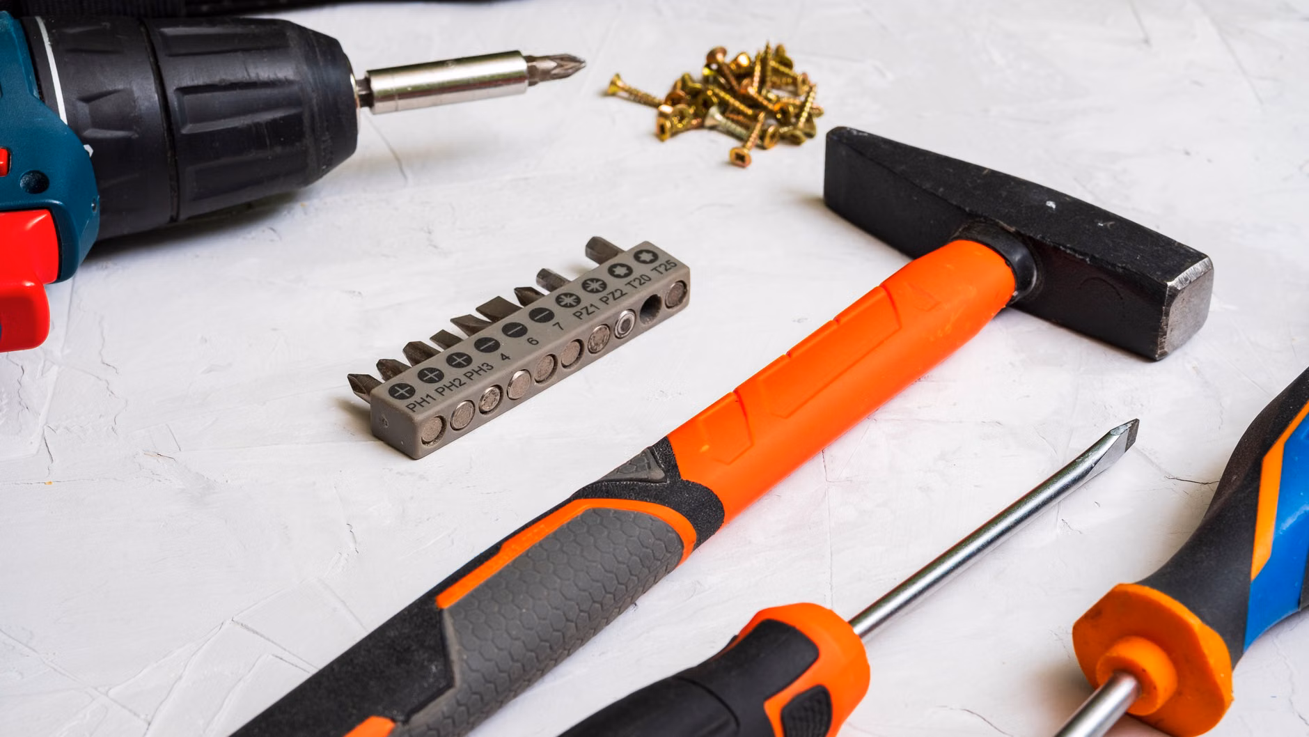 Essential tools for DIY hardware repair on a clean surface.