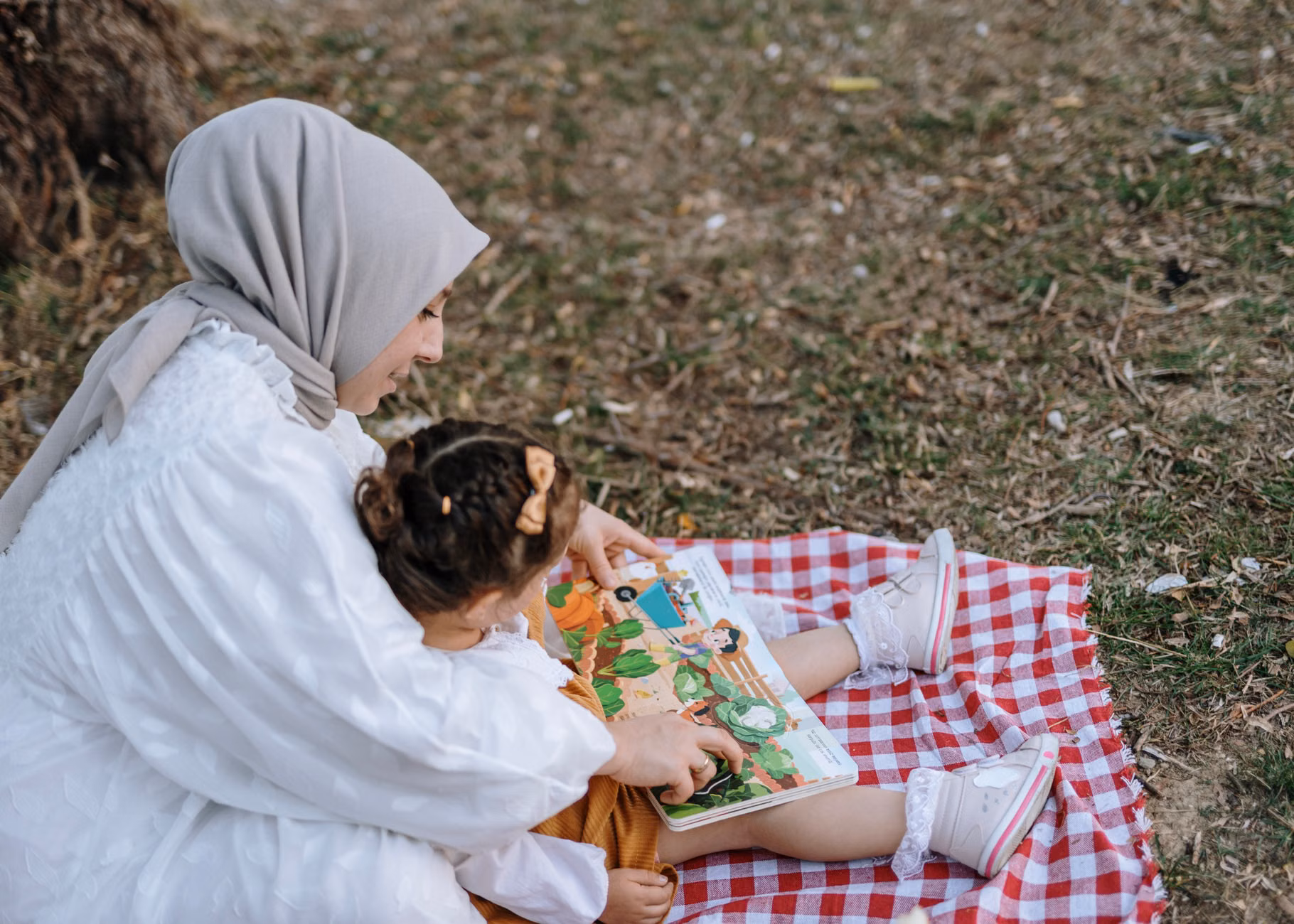 A parent finding time to read in a park.
