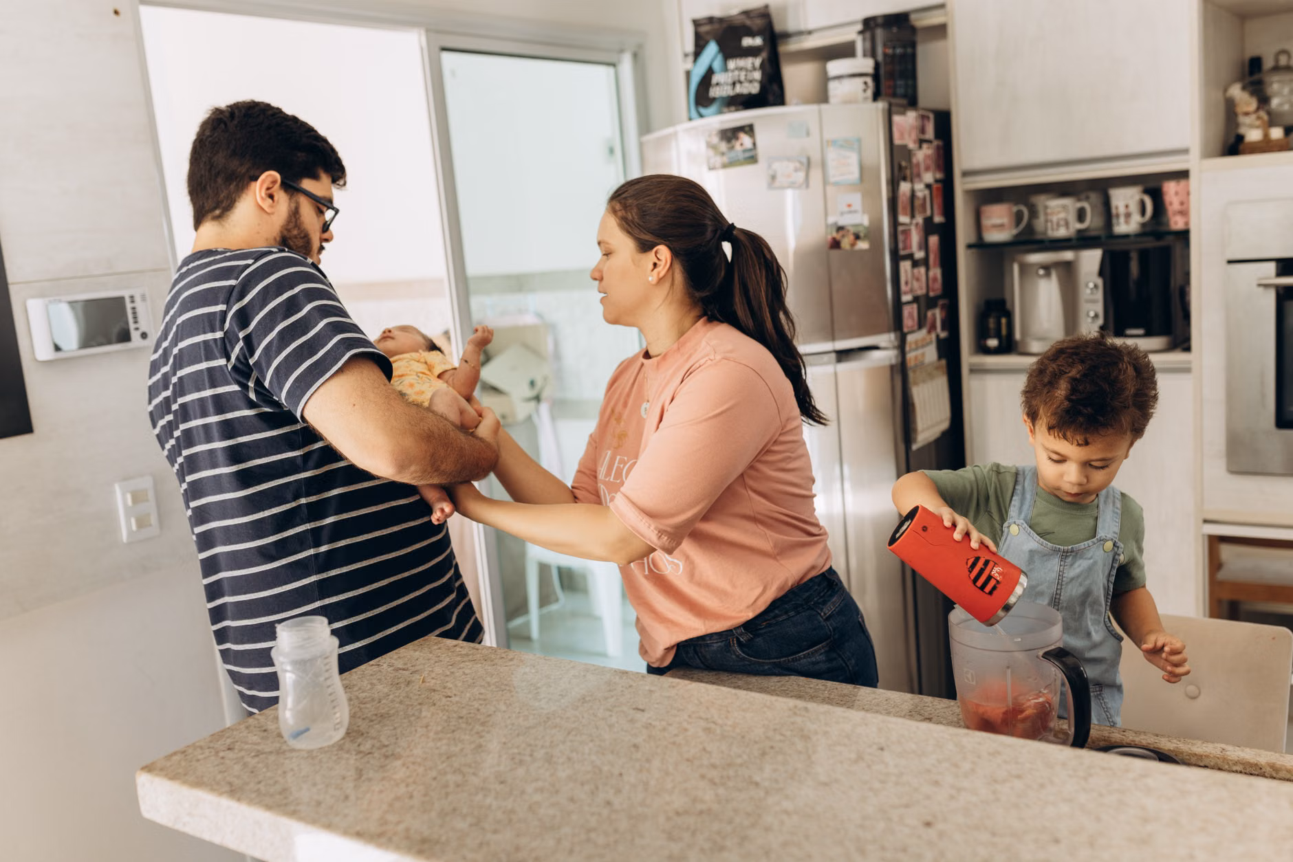 Family fixing a blender together in a home kitchen.
