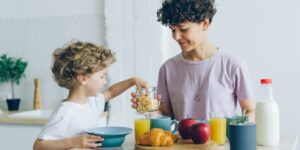 A peaceful morning kitchen scene showing a parent and child preparing breakfast.