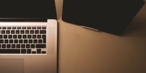 A minimalist home office setup with a laptop and tablet, representing digital family security.