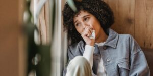A person taking a quiet moment of reflection in a home office setting.