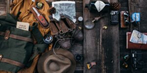Flat lay of diverse family travel gear organized on a floor.