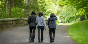 A family of three enjoying a peaceful morning walk in their local neighborhood for a weekend adventure.