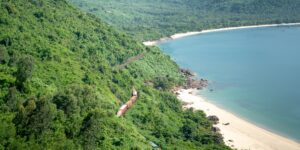 A modern train traveling along a scenic coastline.