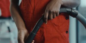 Close-up of hands repairing a vacuum cleaner with a screwdriver.