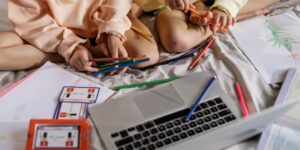 Two children collaborating on a creative project at home.