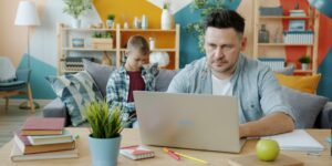 A parent working remotely in a bright, modern home office setting.