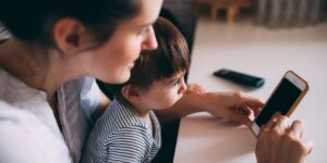 Parent and child exploring their family history on a digital device.
