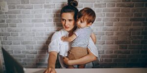 A professional parent working from home with a laptop, symbolizing the balance of remote work and family life.
