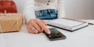 A minimalist home office desk with a smartphone and checklist for a subscription audit.