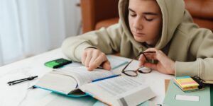 A focused pre-teen studying at a desk in a well-lit room.