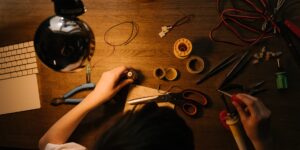 A DIY hardware repair setup on a desk featuring a disassembled wireless mouse and precision tools.