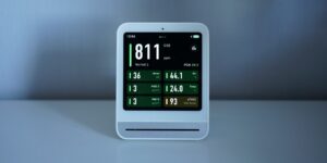 A modern smart home energy monitor in a living room environment.