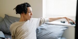 A teenager calmly following a morning routine with a digital checklist in a bright kitchen.