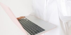 A professional closing their laptop at home to signify the end of the workday.