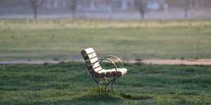 A peaceful city park bench bathed in soft morning light representing quiet tourism.