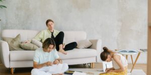 Parents collaborating in a modern living space with children playing in the background.