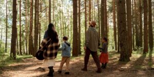 A family enjoying a slow-paced hike together on a forest trail.