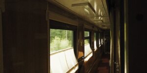 A scenic view from inside a comfortable train carriage looking out at mountains.