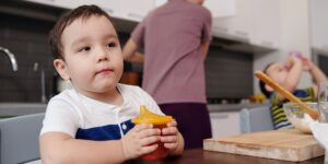 A calm parent and toddler sitting at a kitchen table during a meal, emphasizing a peaceful atmosphere.
