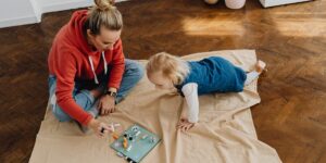 Parent and school-aged child bonding over a board game at home.
