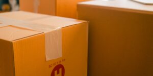 A cardboard shipping box sitting in a modern, sunlit living room representing global delivery.