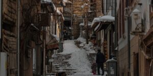 A parent and child walking through a historic, traditional street during a heritage trip.