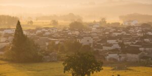 A peaceful rural village scene at golden hour representing the Quiet-Tourism trend.