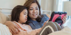 Parent and child reviewing digital memories on a tablet during a family vacation.