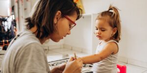 A parent and toddler engaging in an emotional learning activity with flashcards.
