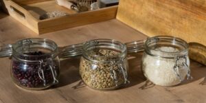 A modern, organized pantry with glass jars of staples in soft lighting.