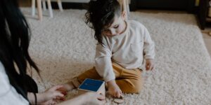 A parent and toddler engaged in play-based learning at home.