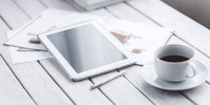 A modern, minimalist workspace featuring a tablet with a family calendar, representing organized digital living.