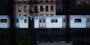 A scenic view of a modern train traveling through the countryside during sunset.